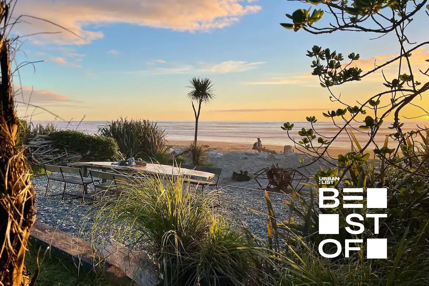 A gorgeous wooden table sits outside this peaceful Hokotika stay for outdoor, beachside dining